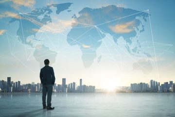 Picture of business man looking at the sky with image of the world.