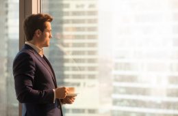 Man looking pensively out of office window.