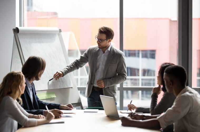 Businessman showing colleagues something on whiteboard